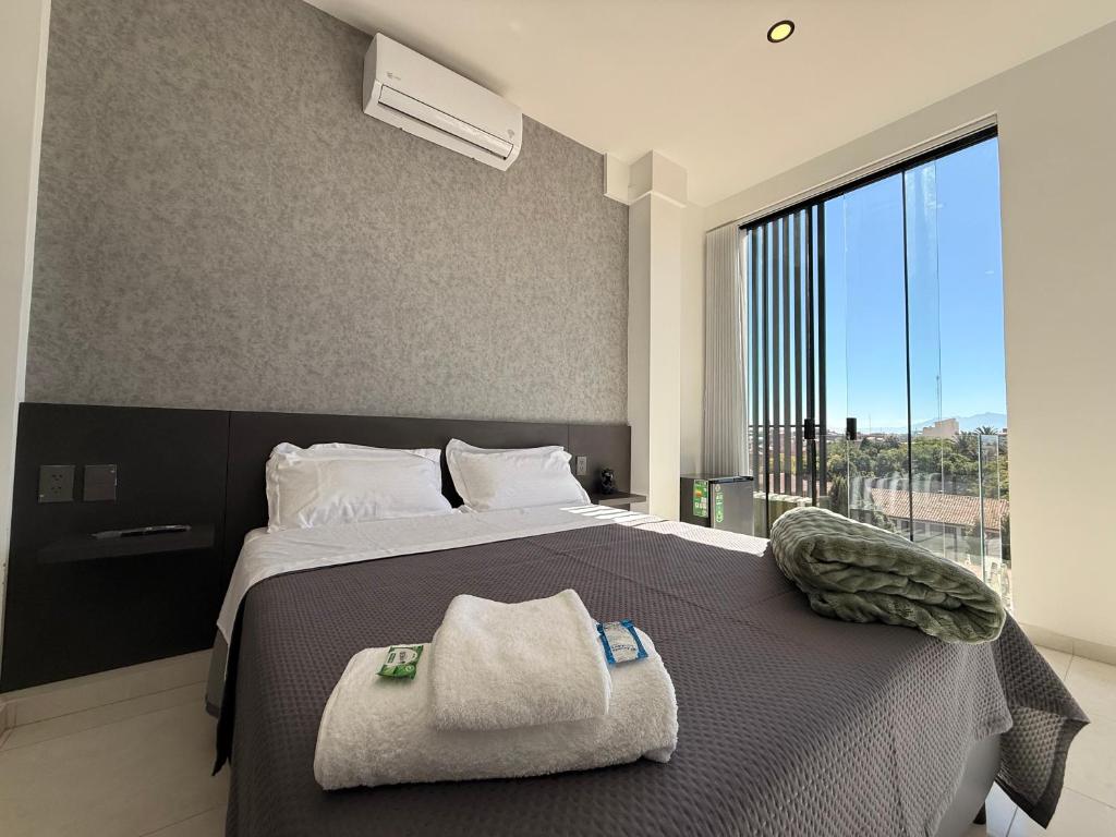 a bedroom with a large bed with a large window at Forty 125 in Tarija