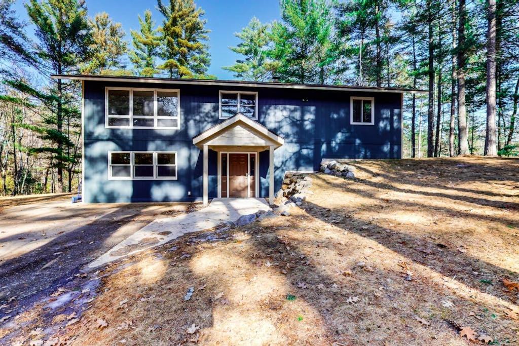 ein blaues Haus mitten im Wald in der Unterkunft Mitchell Point Cottage in Eagle River