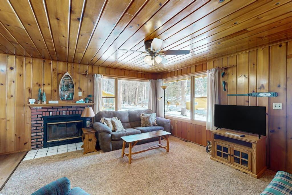 a living room with a couch and a flat screen tv at Chickadee Cabin in Saint Germain