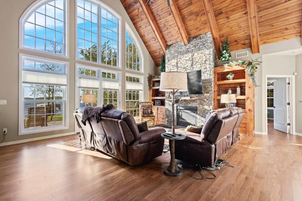 a living room with two leather chairs and a fireplace at North Twin Lake House in Phelps
