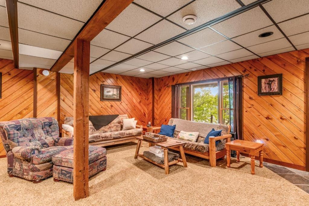 a living room with wooden walls and furniture in a house at Loon's Landing in Mercer