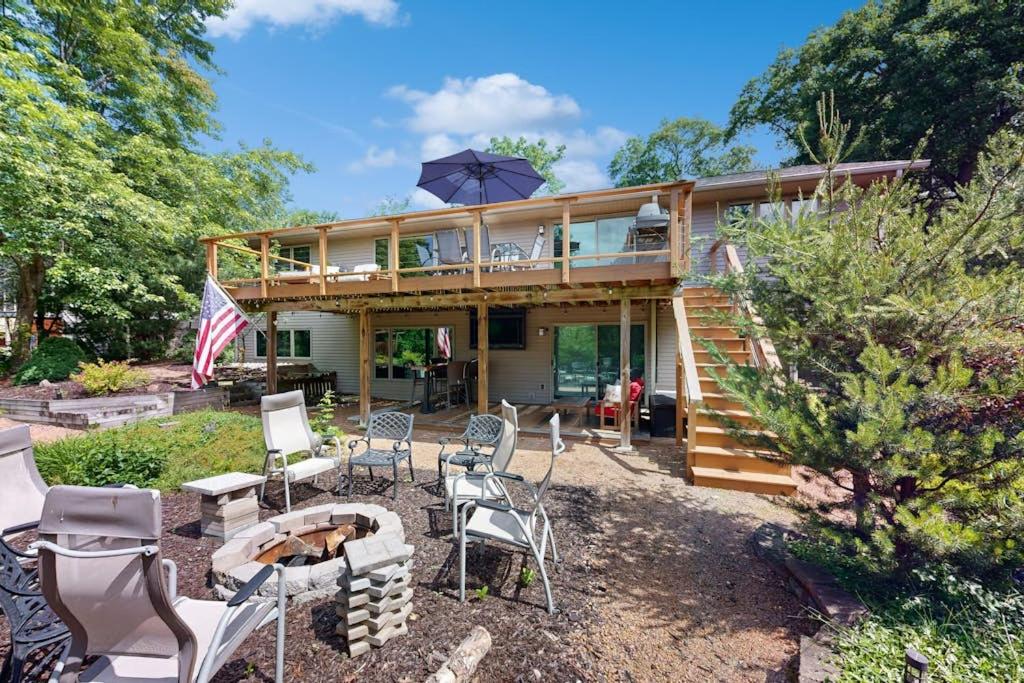 a house with a deck with chairs and an umbrella at Par for the Course in New Rome