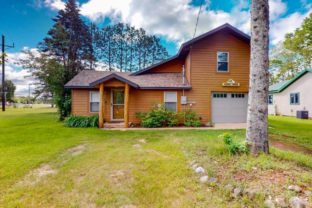 a wooden house with a garage in a yard at The Korn Krib- Main level in Oxbo