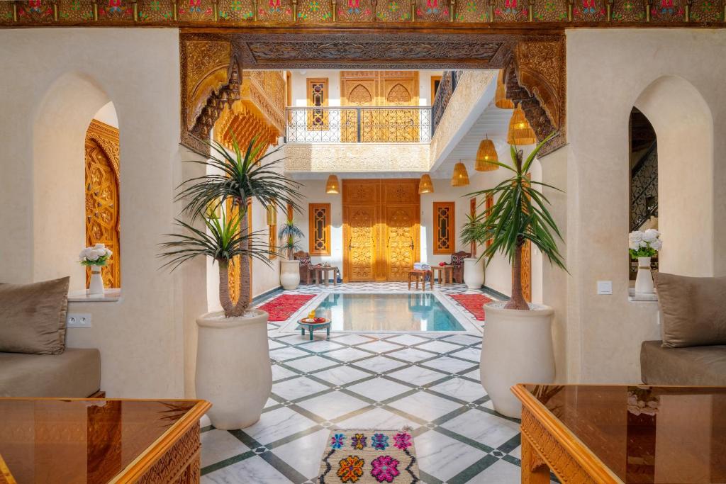 a villa with a swimming pool and a living room at Riad Nadalinn in Marrakesh