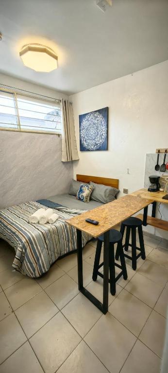 a bedroom with a bed and a wooden table at Loft #1 a una cuadra de Playa Regatas Oyster Suites in Veracruz