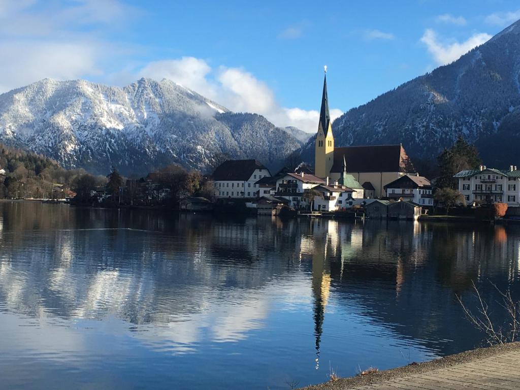 a town on a lake with a church and mountains at Ferientraum Kobellstrasse in Rottach-Egern