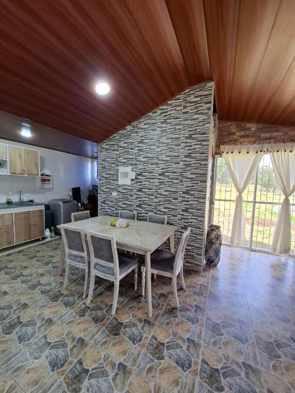 ein Esszimmer mit einem Tisch und einer Backsteinwand in der Unterkunft Suame in Sogamoso