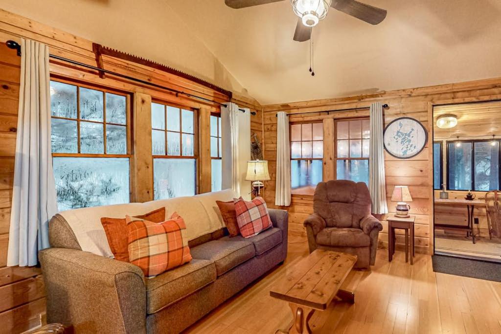 a living room with a couch and a chair at Little Red Lakeside Cabin in Three Lakes