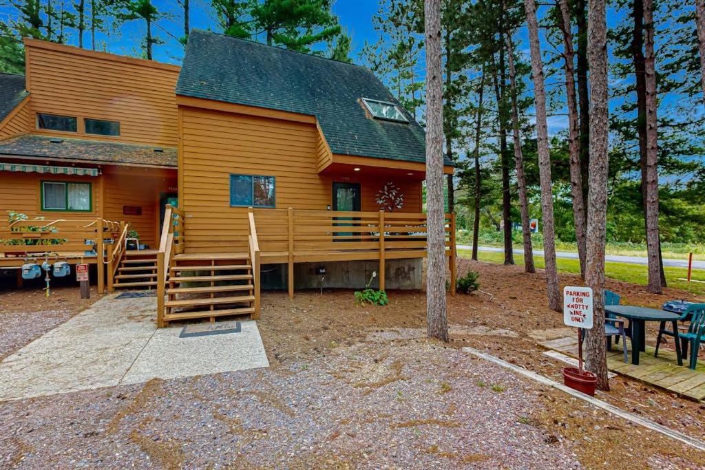 a cabin in the woods with a table and a sign at Knotty Pines in Wisconsin Dells