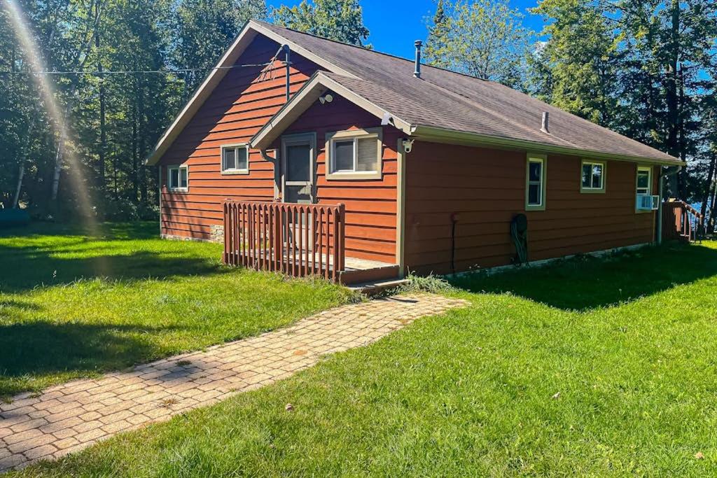 a small house with a fence in the grass at Watermelon Retreat & Suite in Three Lakes