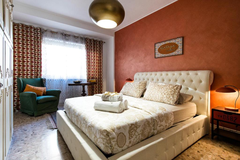 um quarto com uma cama grande e uma cadeira verde em Domus Vintage em Roma