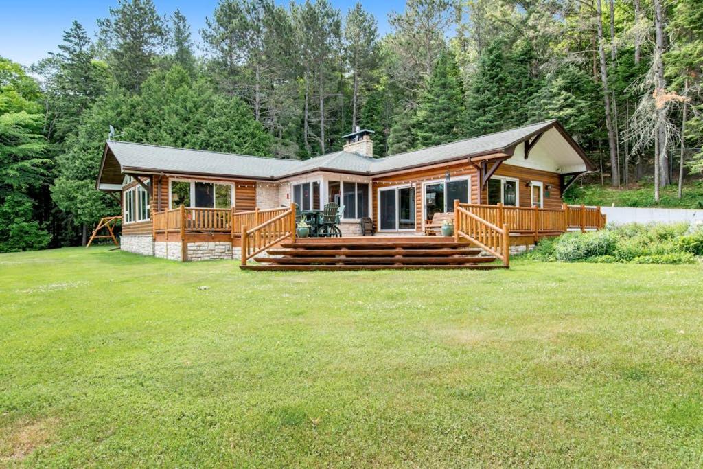 a log home with a large yard with a house at Bayside Secret in Phelps