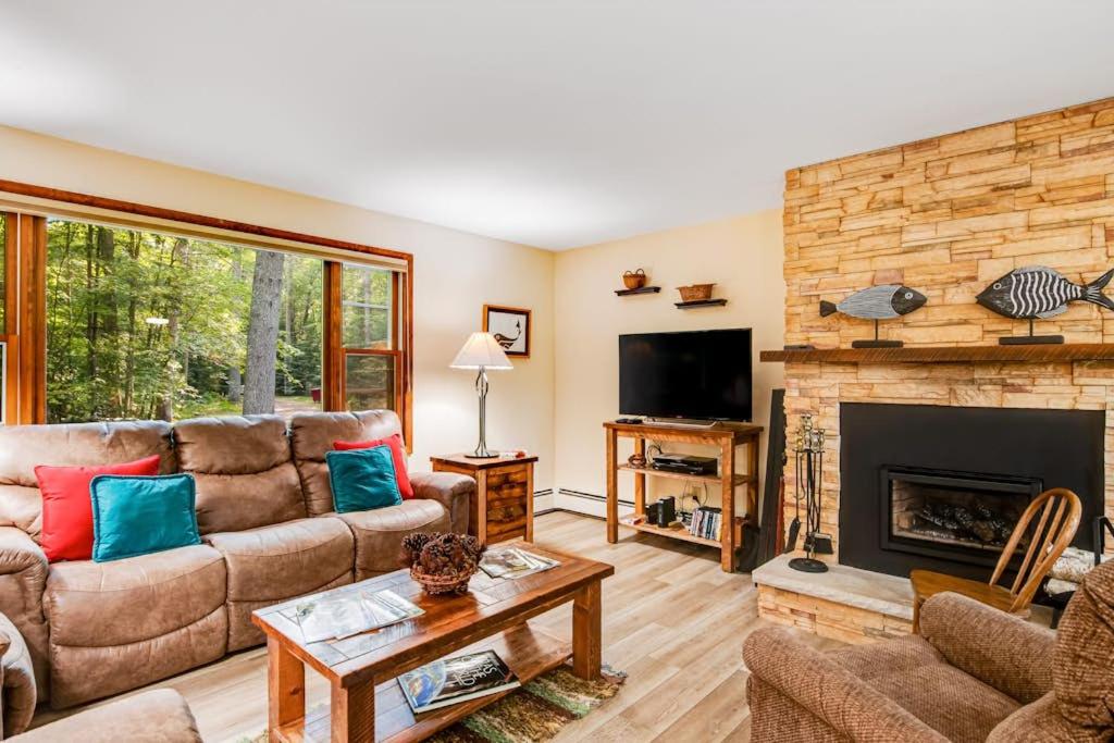 a living room with a couch and a fireplace at Northwoods Paradise in Eagle River