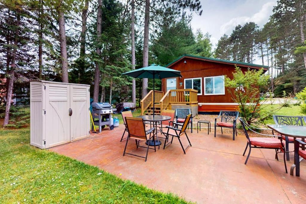 a patio with tables and chairs and a house at Catfish Cottage B in Eagle River