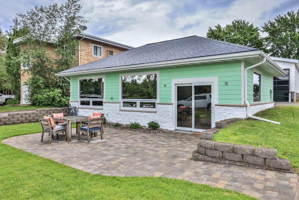 a green and white house with a table and chairs at The Studio in Minocqua
