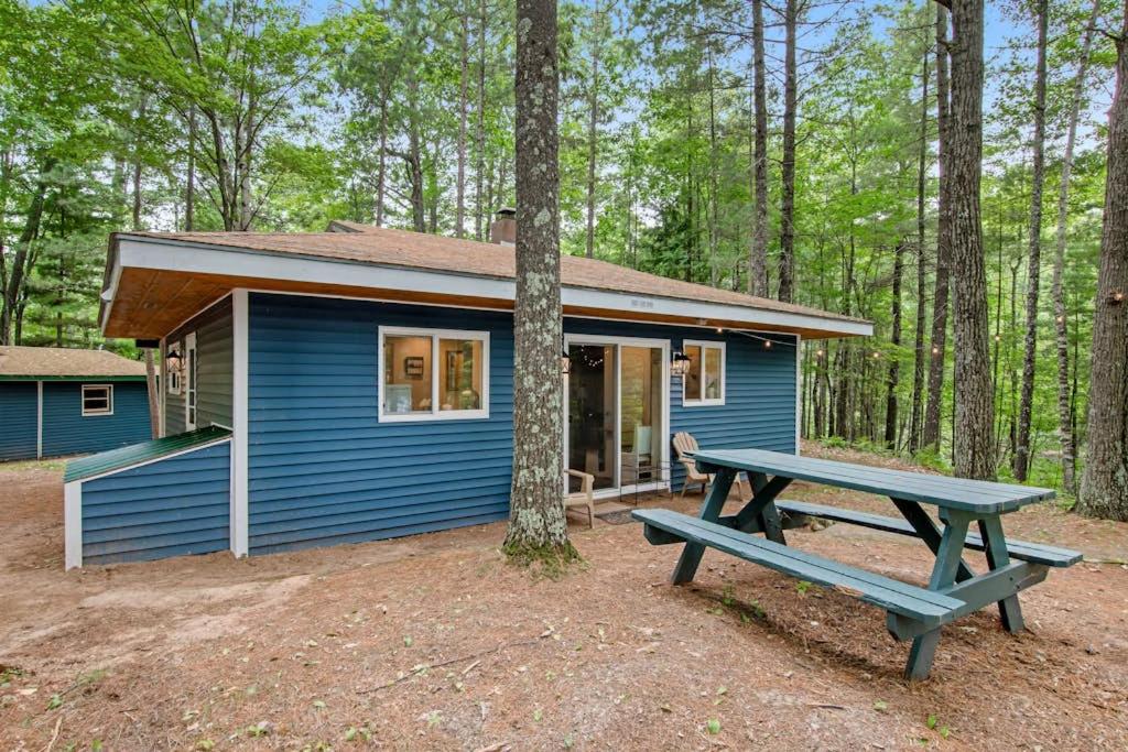a blue tiny house with a picnic table in front of it at Cove View in Minocqua