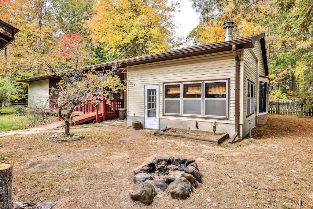 a small house in a yard with a fire pit at Tranquility Base in Rhinelander