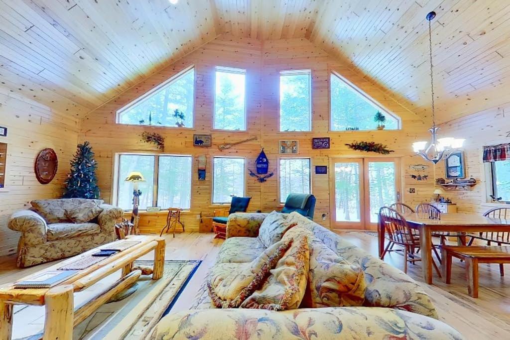 a living room with a wooden ceiling with windows at Shady Lane Lodge in Eagle River