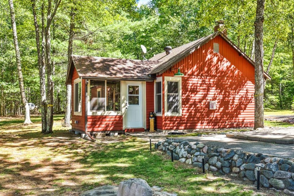 a red tiny house in the middle of a forest at The Nut House in Eagle River