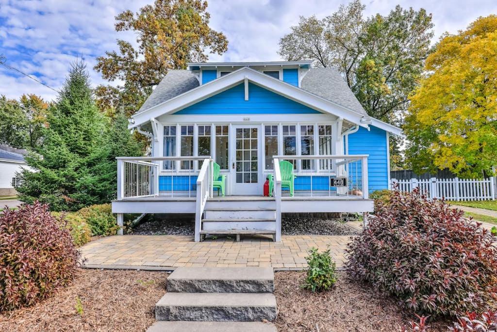 a blue house with a front porch and stairs at The Blue Cottage in Minocqua