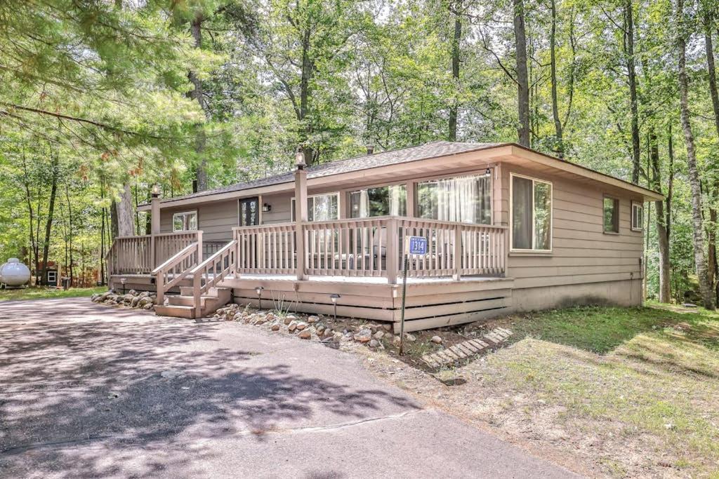 a small house with a large porch in the woods at The Lazy Bear in Saint Germain