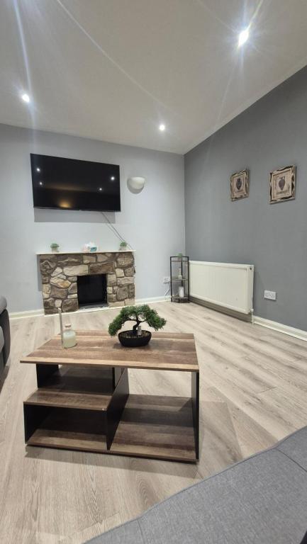 a living room with a table and a fireplace at Easy Stay Jerviston in Mossend
