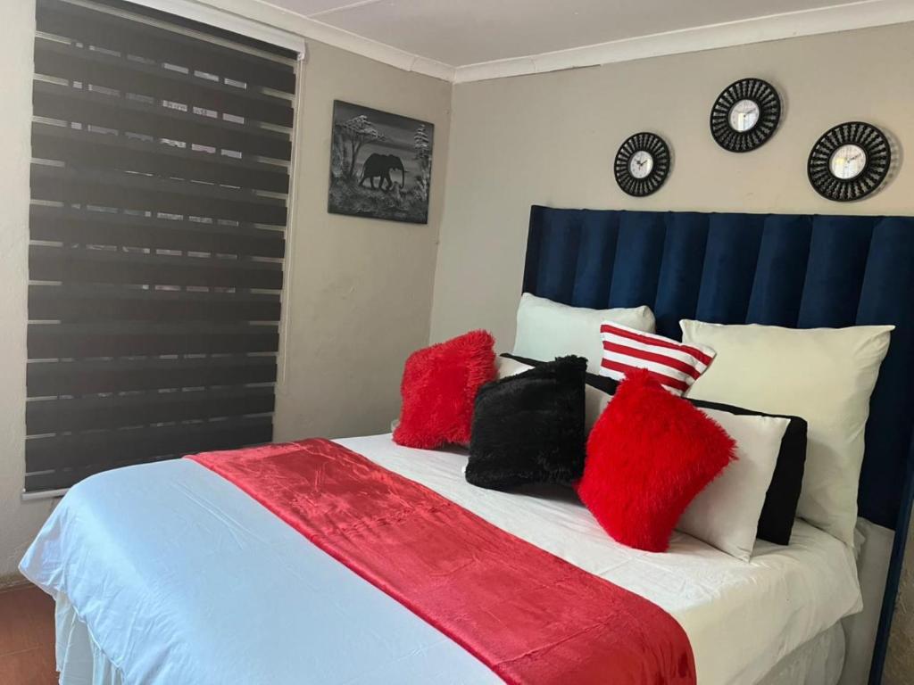 a bedroom with a bed with red pillows on it at EcoGreen B&B On 222 Botha in Northam