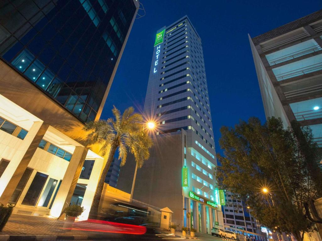 a tall building in a city at night at ibis Styles Manama Diplomatic Area in Manama