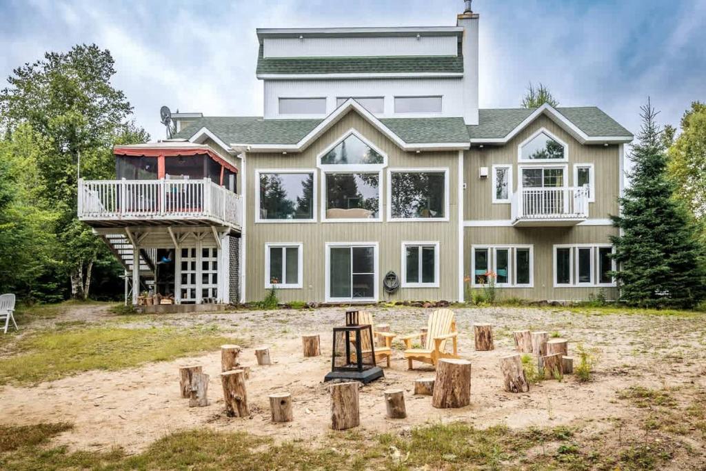 a large house with a playground in front of it at Le Chaleureux du Lac Blanc - Nominingue in Nominingue