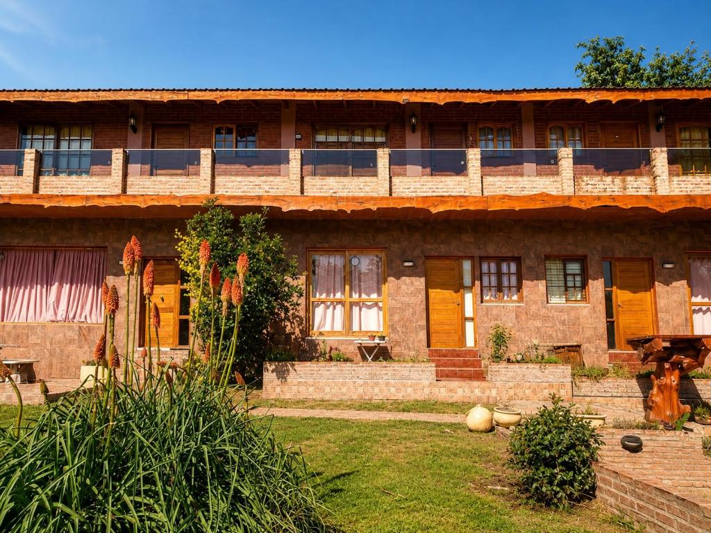 an old brick building with yellow doors and windows at Ohana Apartments (solo familias) in Villa Carlos Paz