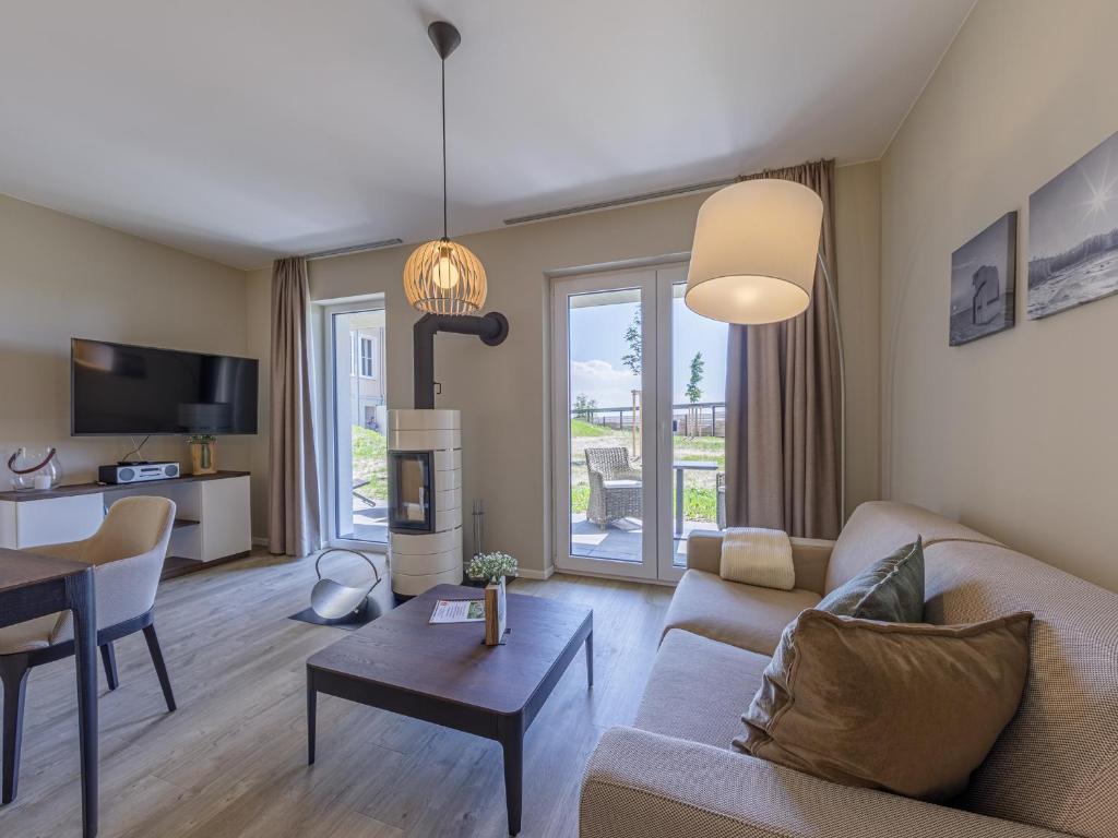 a living room with a couch and a table at Großer Strandkorb - Stilvolles Ferienapartment in der Alten Seefahrtsschule in Wustrow