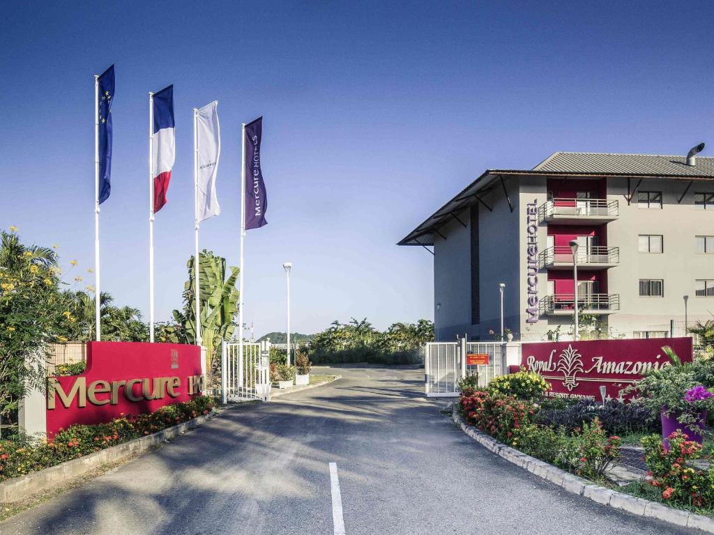 a road with flags in front of a hotel at Mercure Cayenne Royal Amazonia in Cayenne