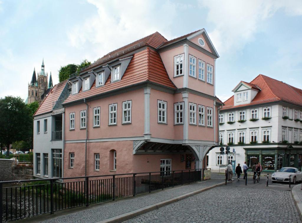 ein großes Gebäude mit rotem Dach auf einer Straße in der Unterkunft Pension Sackpfeifenmühle in Erfurt
