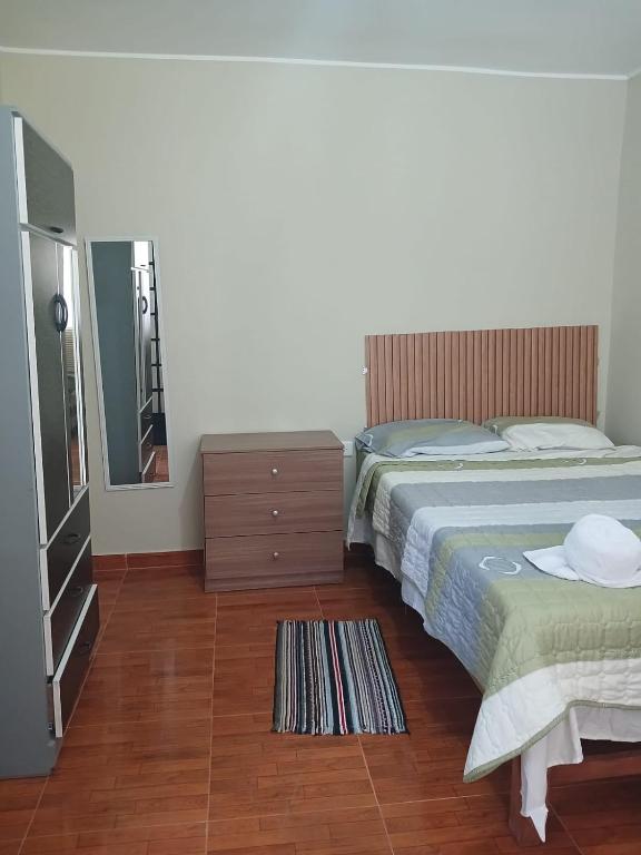 a bedroom with a bed and a dresser and a mirror at Alójate Huánuco in Huánuco