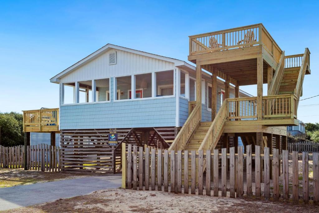 a large wooden house with a wooden fence at 4011 - The Dog`s House in Kitty Hawk
