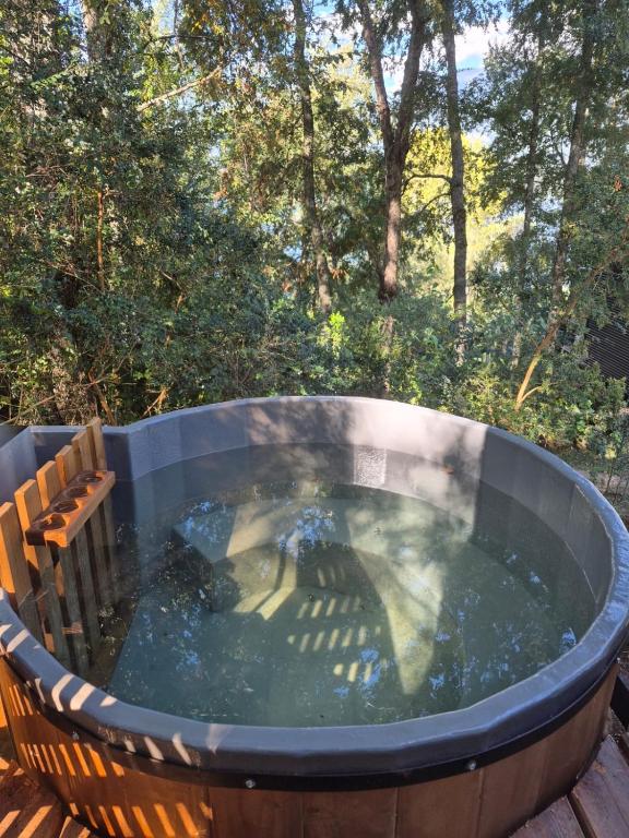 a hot tub on a deck with a bench around it at cabañasmanantialpanguipulli in Panguipulli