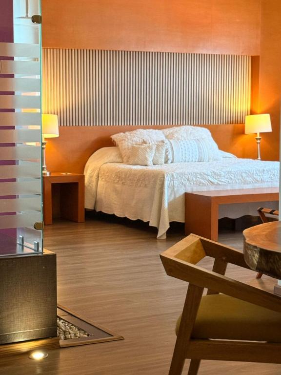 a bedroom with a large bed and a table at Hotel Tlayolan in Ciudad Guzmán