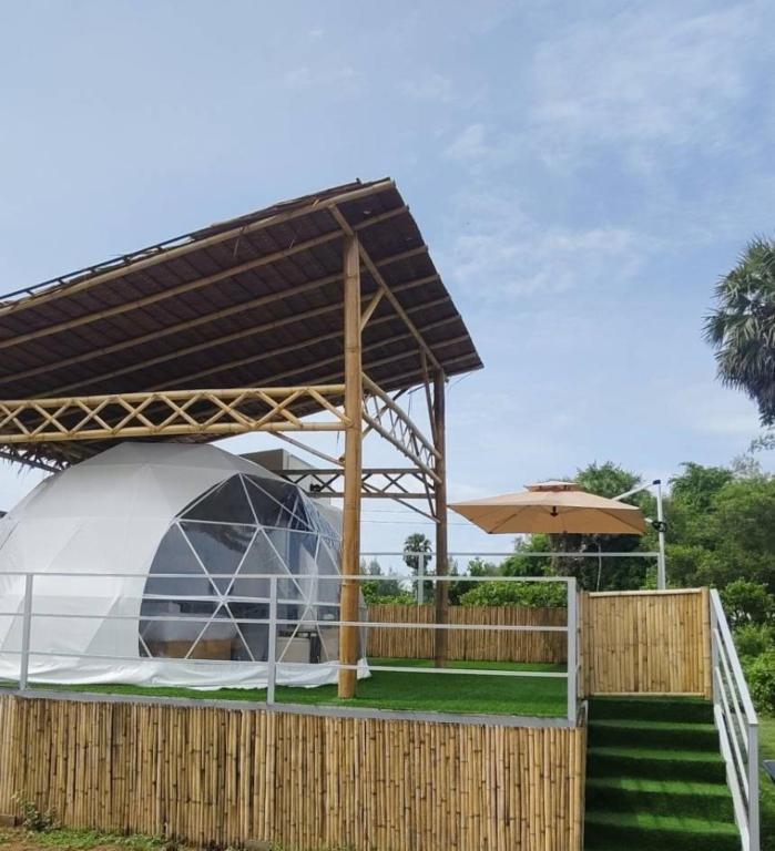 a tent under a canopy next to a wooden fence at Koala Glamping Krabi in Krabi