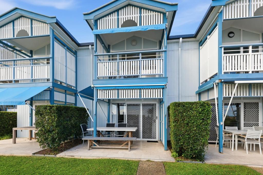 a building with blue balconies and a table and chairs at Villa 3 Beach Front Tangalooma in Tangalooma