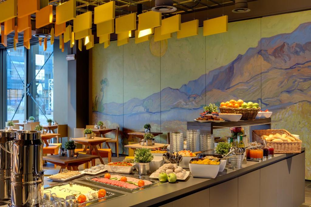 a buffet line with fruits and vegetables on display at MEININGER Hotel Amsterdam City West in Amsterdam