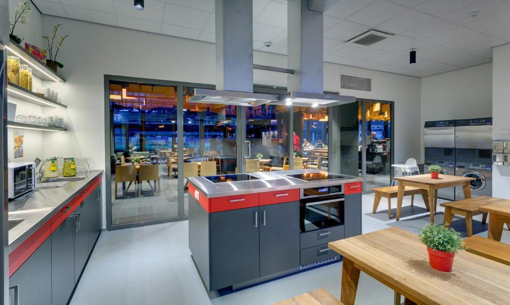 a kitchen with stainless steel appliances and a table at MEININGER Hotel Amsterdam City West in Amsterdam