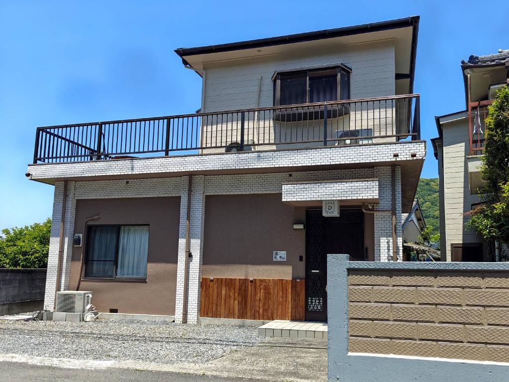 a house with a balcony on top of it at 貸切宿ひととき in Numazu