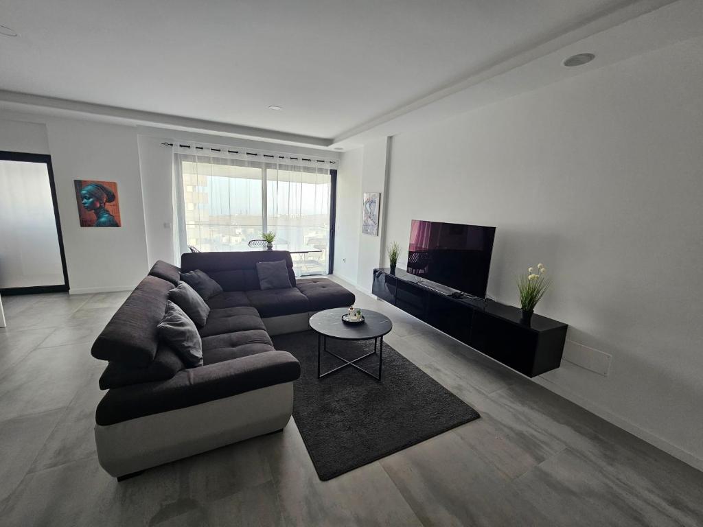 a living room with a couch and a tv at Palmarejo grande in Praia