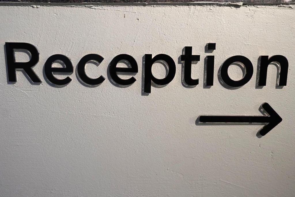 a sign with the word reception on a wall at TheCloud Hotel in Nizāmābād