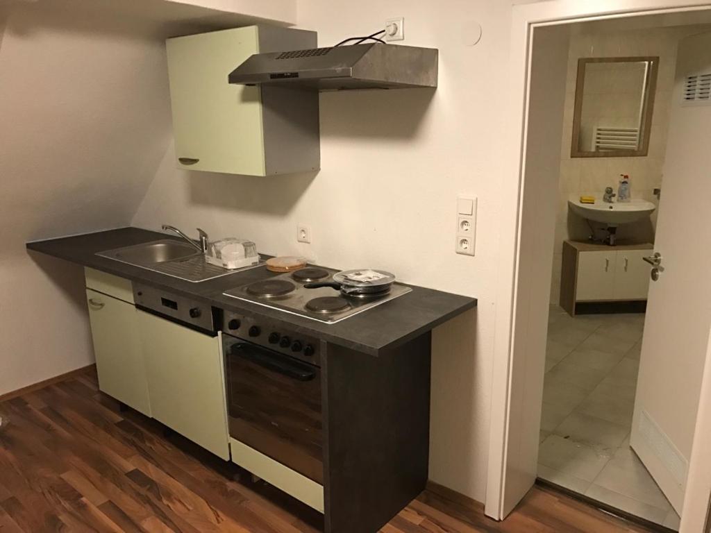 eine kleine Küche mit Herd und Spüle in der Unterkunft Vatan Apartment in Fürth