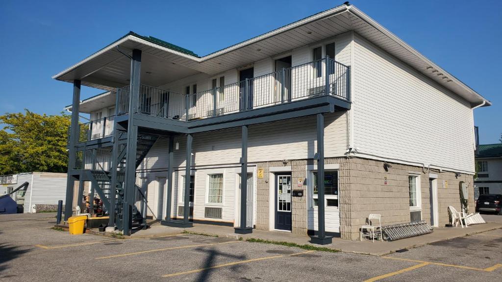 a large white building with a second story at Bayview Inn Orillia in Orillia