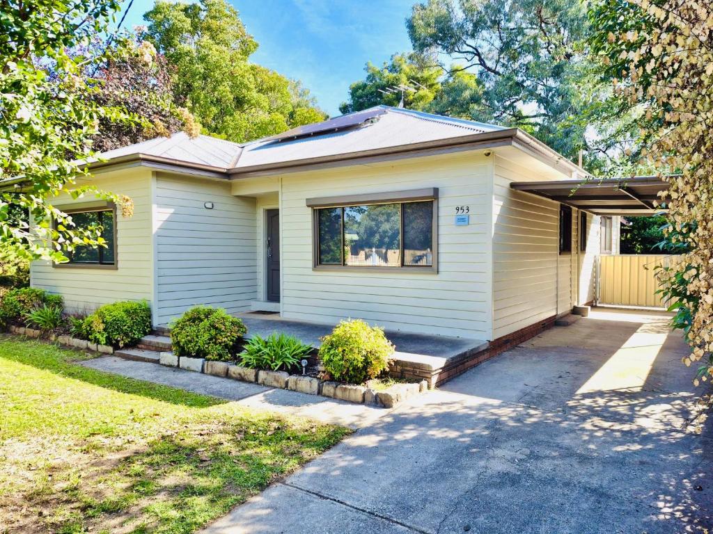 a white house with a driveway at Wombat Cottage Albury in Albury