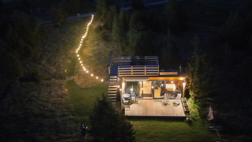 a small house with lights on the side of a field at 2me2 - getaway in Värati in Värati