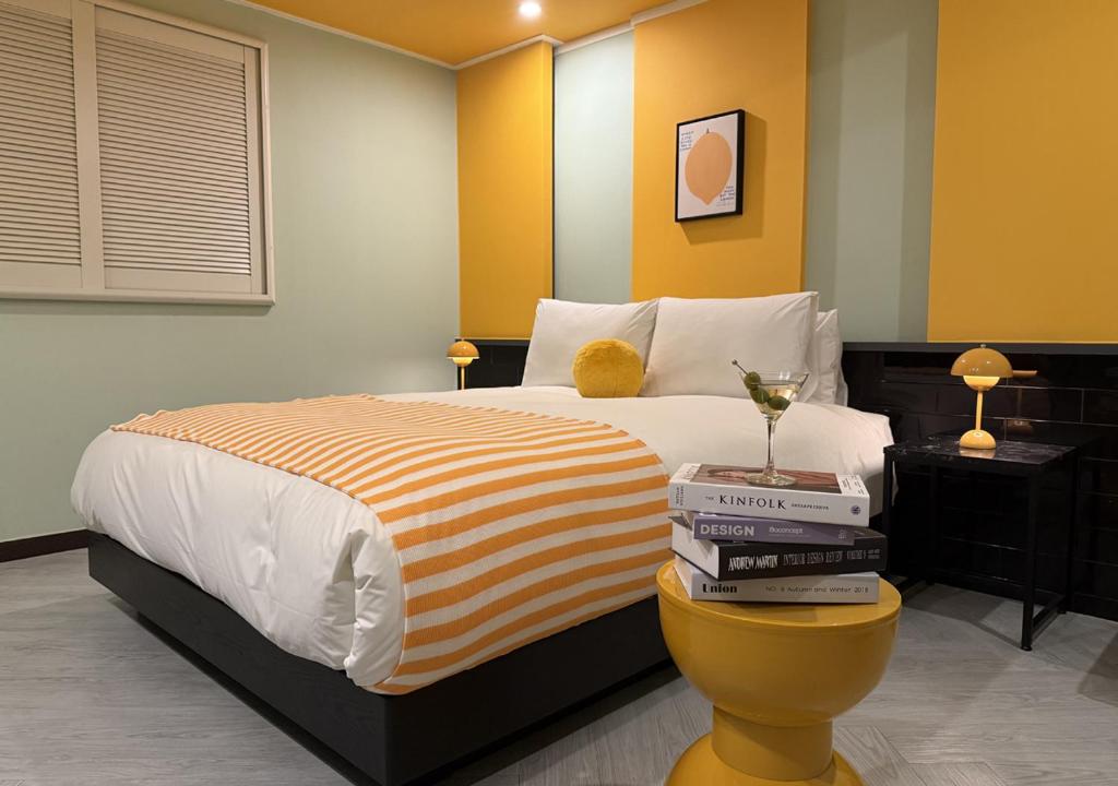 a bedroom with a bed with a stack of books at Waikei Hotel in Suwon