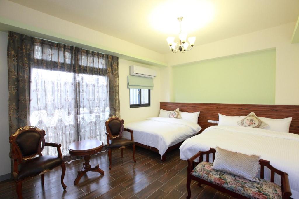 - une chambre avec 2 lits, des chaises et une fenêtre dans l'établissement Yulibnb, à Yuli